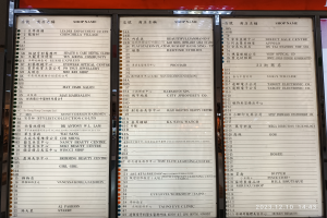 Ein Speisekartenständer mit chinesischer Schrift vor einem Gebäude, der wahrscheinlich die verfügbaren Gerichte auflistet.