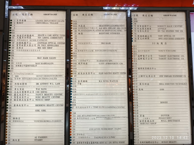 Ein Speisekartenständer mit chinesischer Schrift vor einem Gebäude, der wahrscheinlich die verfügbaren Gerichte auflistet.