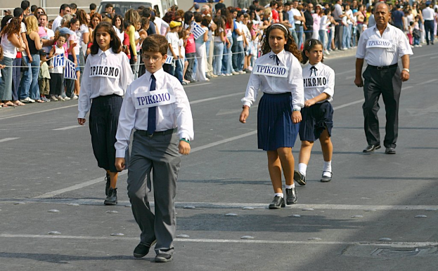 Eine Gruppe von Menschen, die auf der Straße gehen und Abzeichen auf ihren Hemden tragen, mit einer großen Menge, die sich um die Straße versammelt.