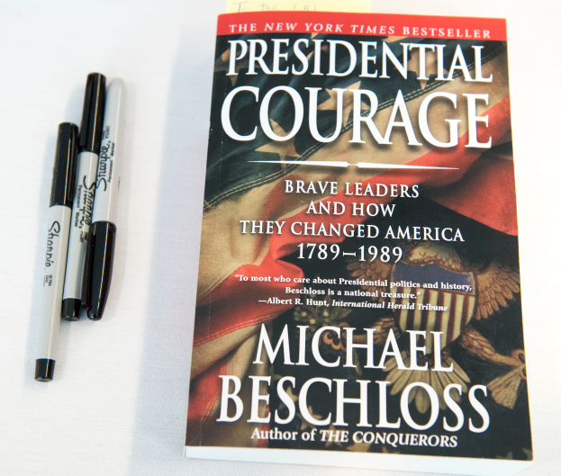 Eine weiße Fläche mit einem Buch namens "Präsidialcourage: Mutige Führer und wie sie Amerika 1789-1989 veränderten" von Michael Beschloss, begleitet von zwei Stiften.