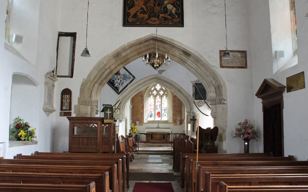 Ein Innenblick in eine Kirche mit Blumenvasen, Bänken, Fotorahmen und Lichtern.