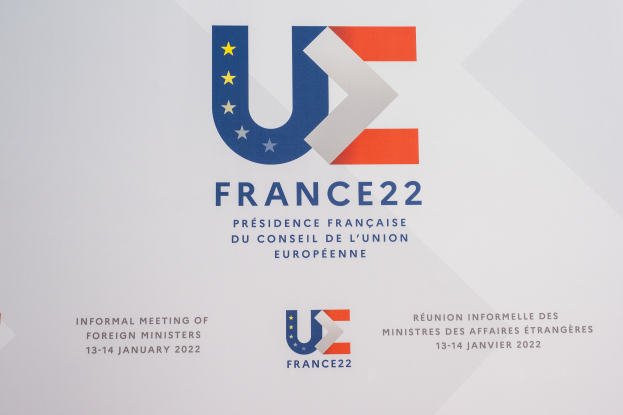 Ein Plakat mit dem Text "Frankreich 22 - Informelles Treffen der Außenminister" und dem Logo der Europäischen Union, das ein blauer Kreis mit einem weißen Rand, einem weißen Stern in der Mitte und einem weißen Rand ist.