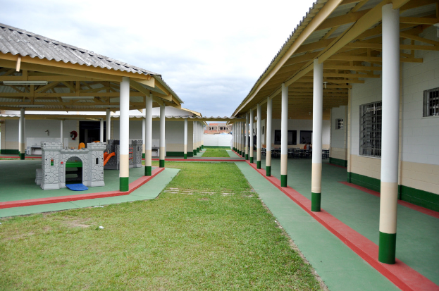 Unterstände mit Säulen und Räumen, umgeben von einer Rasenfläche.