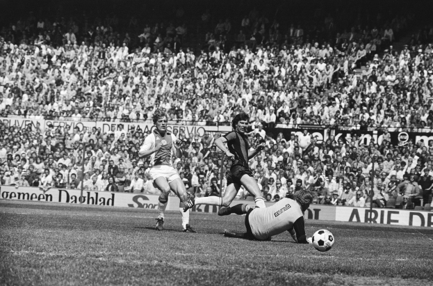 Schwarzes und weißes Foto von Männern, die auf einem Feld Fußball spielen, mit Zuschauern im Hintergrund und einer Tafel Bundesliga 1978-79 Ajax 1-1 Hannover 96.