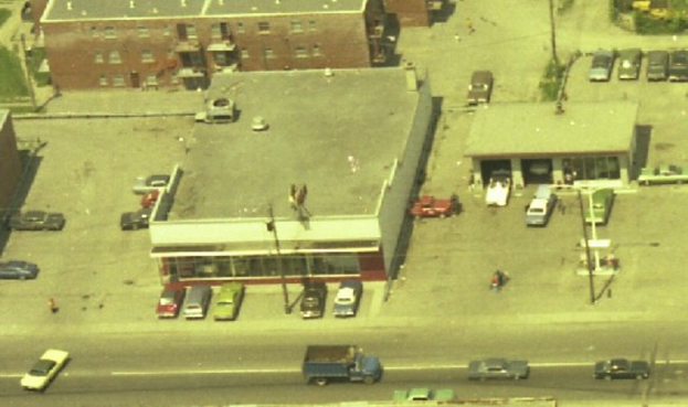 Eine Luftaufnahme einer Stadt mit zahlreichen Autos um die Gebäude herum und einigen Autos auf der Straße.