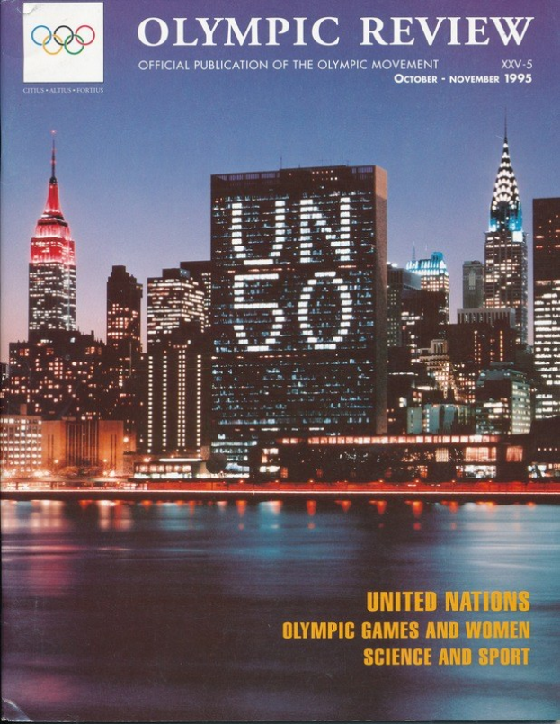 Buch mit dem Titel "Olympic Review Offizielle Veröffentlichung der Olympischen Bewegung" mit einem Stadtbild auf dem Cover, das auf einer flachen Oberfläche liegt.