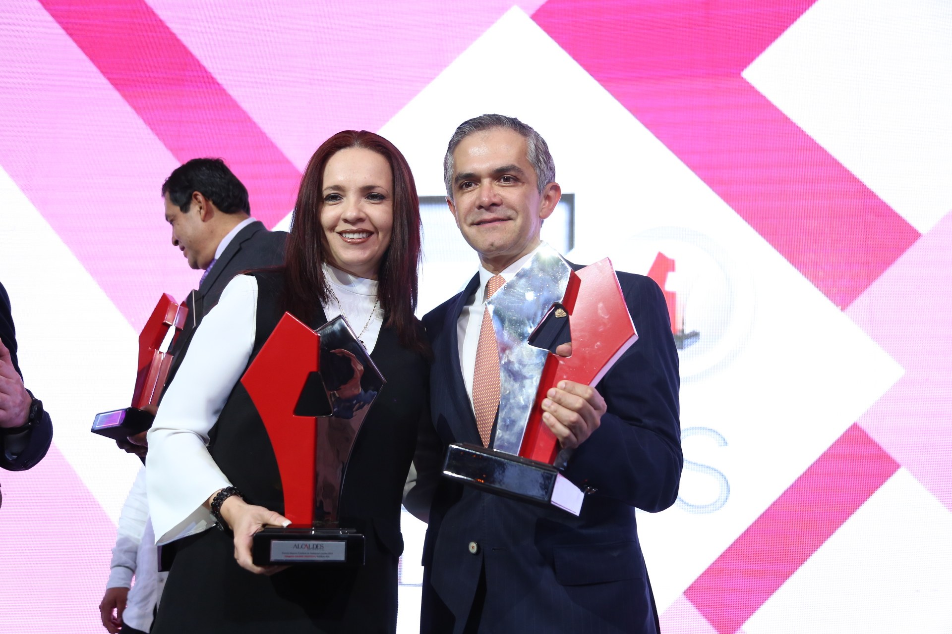 Eine Gruppe von Menschen auf einer Bühne mit Auszeichnungen, Lautsprechern darunter und einem Bildschirm im Hintergrund mit der Aufschrift "Classy Awards 2019".