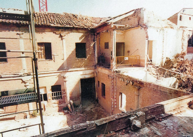 Ein teilweise abgerissener Bau mit Barrikade, sichtbaren Fenstern und einem Gegenstand, der wie eine Leiter aussieht.