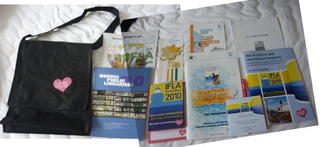 Eine Tasche mit 'Bücherliebhaber' darauf und einige Bücher liegen auf einem Bett.