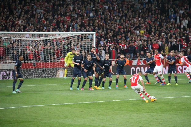 Fussballspieler auf einem Feld mit einer gro├čen Menge im Hintergrund.