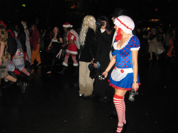 Eine Gruppe von Menschen, einige in Theaterkostümen, gehen über einen Boden.