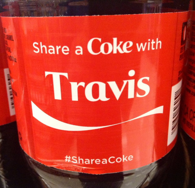 Eine Coca-Cola-Flasche mit der Aufschrift "Teile eine Coke mit TRAVIS".