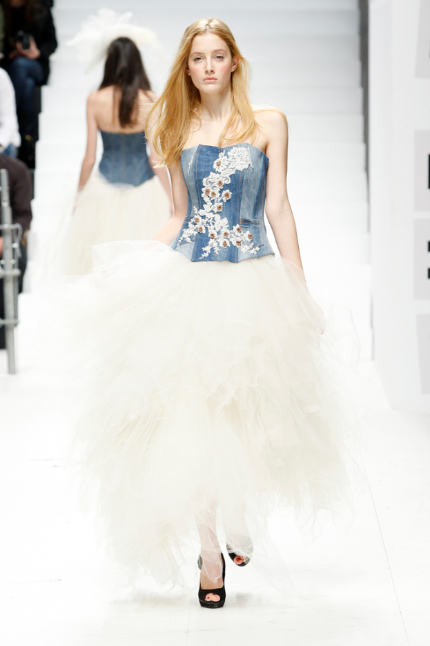 Zwei Frauen auf dem Laufsteg in Designerkleidung.