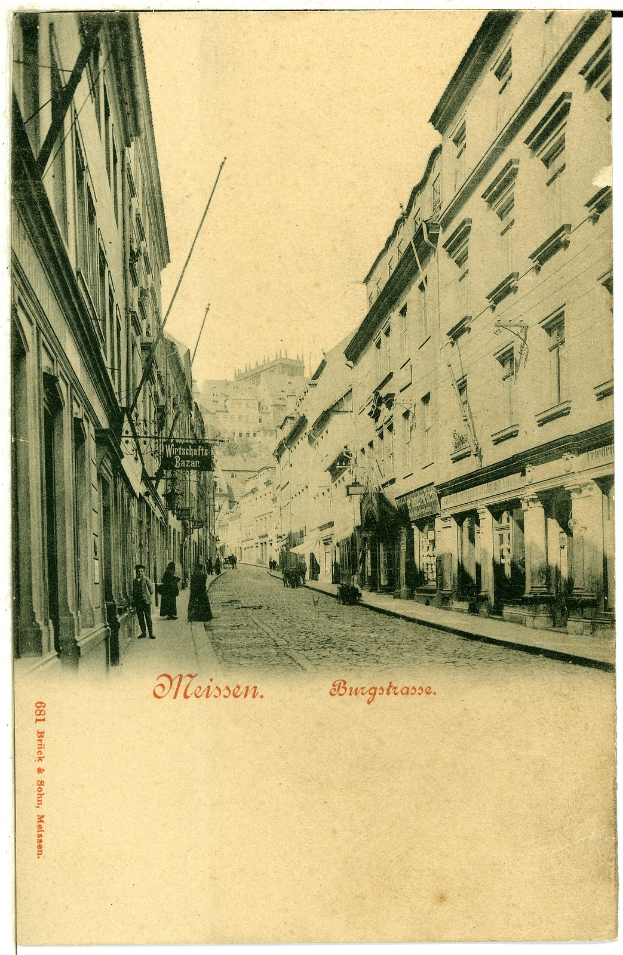 Ein altes Foto einer Stadtstraße mit Menschen, die darauf gehen, Gebäuden auf beiden Seiten und Text unten.