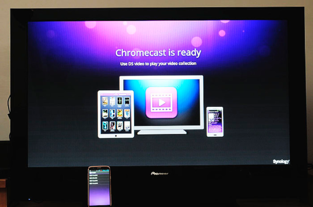 Ein Mobiltelefon mit Text im Vordergrund und einem Fernseher in der Mitte, der Bilder von elektronischen Geräten und Text auf seinem Bildschirm zeigt.