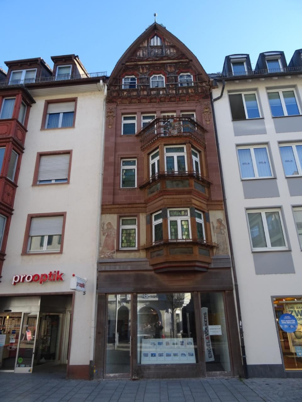 Geschäftsgebäude mit mehreren Fenstern zum Verkauf, das sich auf einer Straße mit einem klaren blauen Himmel in Heidelberg, Deutschland, befindet.
