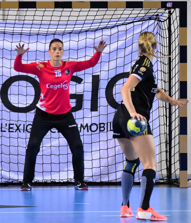 Zwei Frauen beim Handballspiel auf einem Feld, eine hält einen Ball, im Hintergrund ein Netz und eine Fahne mit der Aufschrift "Futsal-Weltmeisterschaft 2019".