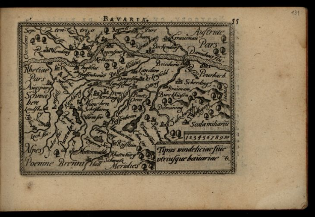 Ein altes Buch mit einer detaillierten Karte von Bayern auf dem Cover, das verschiedene Städte und Ortschaften zeigt, vor einem schwarzen Hintergrund.