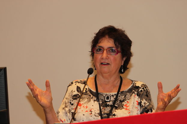 Eine Frau steht an einem Podium mit einem daran befestigten Mikrofon.