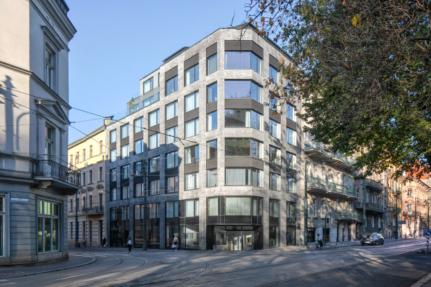 Großes modernes Bürogebäude mit vielen Fenstern, umgeben von Straßeninfrastruktur, Fahrzeugen, Fußgängern, Bäumen und einem bewölkten Himmel, das als neue Firmenzentrale dient.