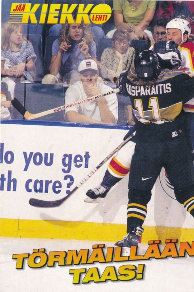 Ein Eishockeyspieler in Aktion auf dem Eis, der einen Helm tr├Ągt und einen Hockeyschl├Ąger h├Ąlt, mit ein paar Menschen im Hintergrund, die auf St├╝hlen sitzen, und Text am unteren Rand des Bildes.