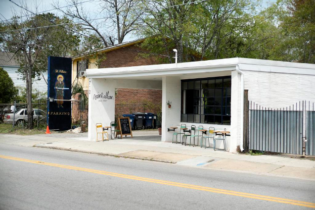 Ein Restaurantgebäude, das an einer Straße liegt, mit Bäumen im Hintergrund.