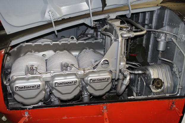 Ein Close-up-Blick auf einen Automotor in einer Garage, der den Motorblock, Kolben, Ventile und andere Komponenten zeigt.