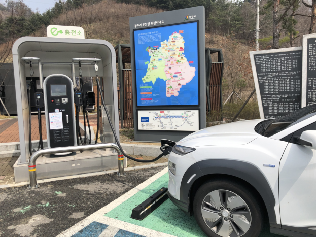 Elektroauto-Ladestation in Seoul, Südkorea, mit Bäumen und Himmel im Hintergrund.
