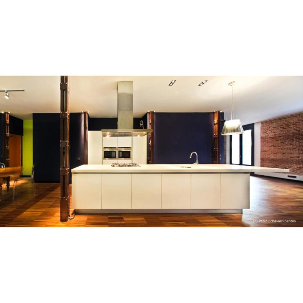 Eine Kücheninneneinrichtung mit einer weißen Plattform, Spüle, Kühlschrank, Schranktüren, schwarzer Wand, Hängelampe, brauner Ziegelwand, Glastür und Holzboden.