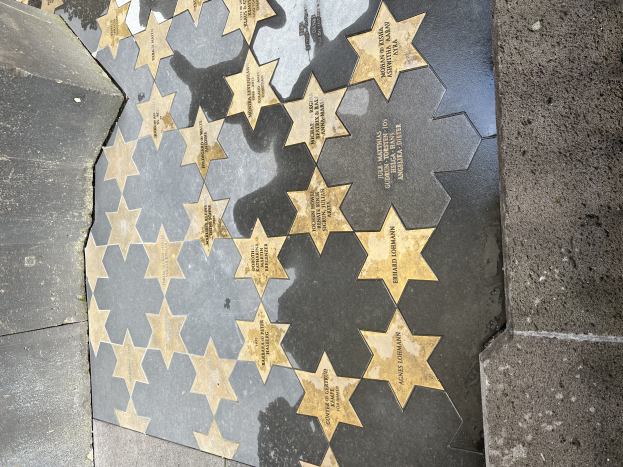 Ein Stern auf dem Hollywood Walk of Fame in Los Angeles, Kalifornien, bestehend aus fünf kleineren Sternen mit eingraviertem Text, flankiert von Mauern auf beiden Seiten.