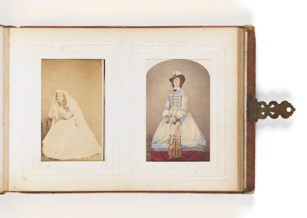 Ein altes Buch mit einer Illustration einer Braut in einem weißen Kleid mit Schleier und Tiara und eines Bräutigams in einem Anzug, der einen Strauß hält, beide strahlend glücklich.