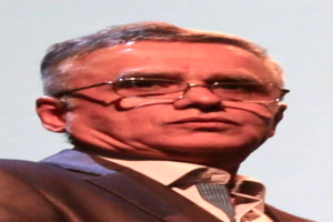 Ein Mann in Blazer, Krawatte und Brille, der vor einem weißen Hintergrund steht und als CEO der Bank of England identifiziert wird.