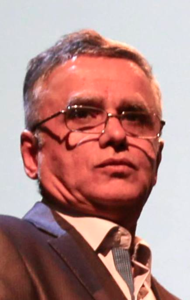 Ein Mann in Blazer, Krawatte und Brille, der vor einem weißen Hintergrund steht und als CEO der Bank of England identifiziert wird.