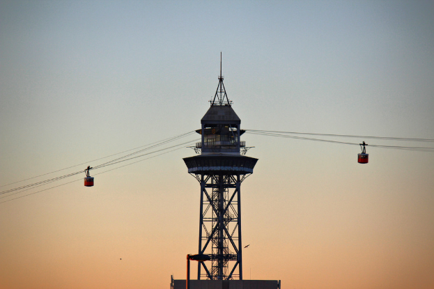 Mehrere Kabelbahnen, die an einem Turm im Hintergrund hängen.