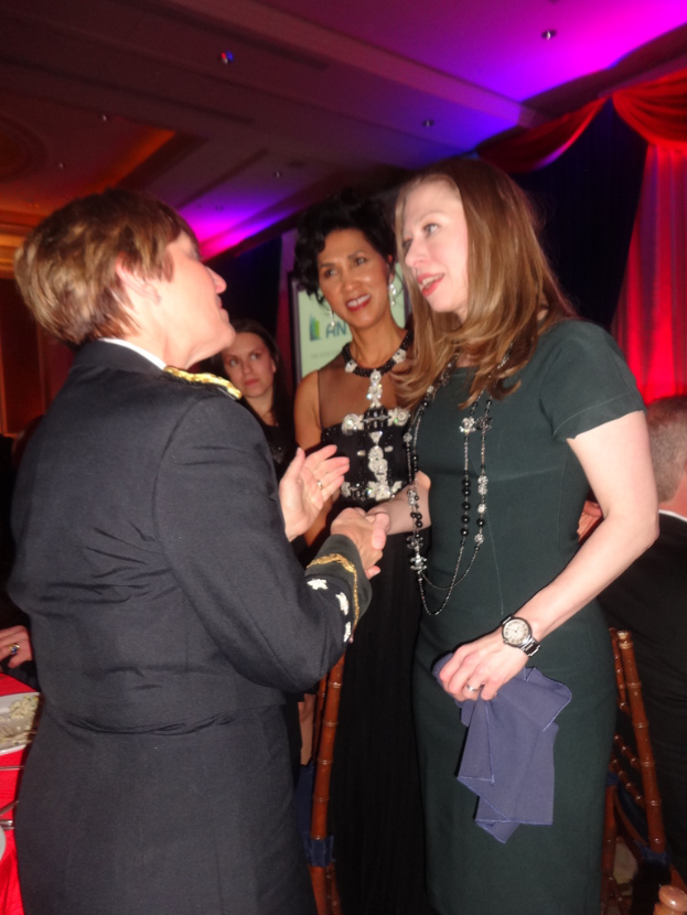 Mehrere Oldtimer vor einer Wand mit verschiedenen Zubehörteilen geparkt, mit einer Säule auf der linken Seite.